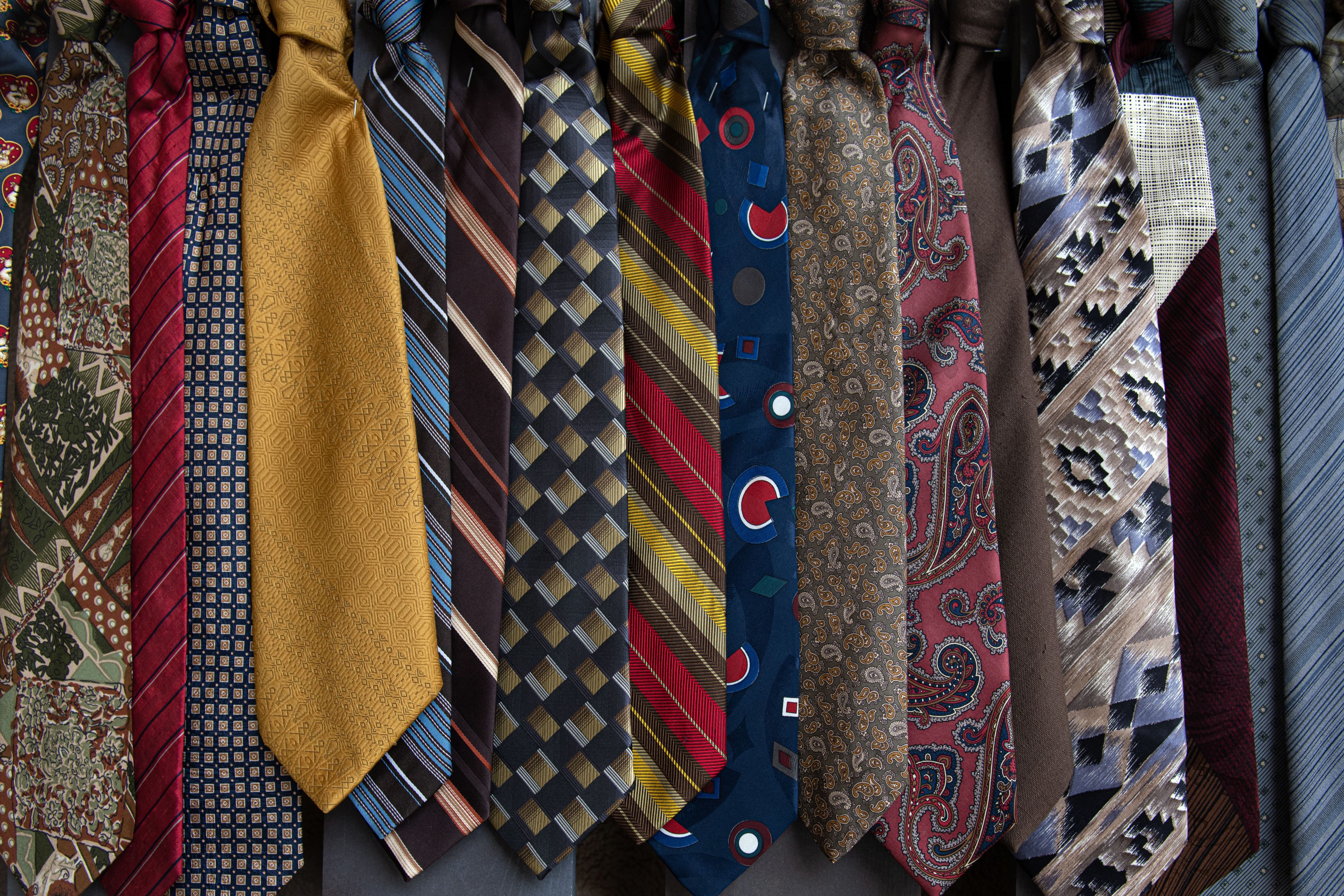 brown and white necktie on blue and white floral textile