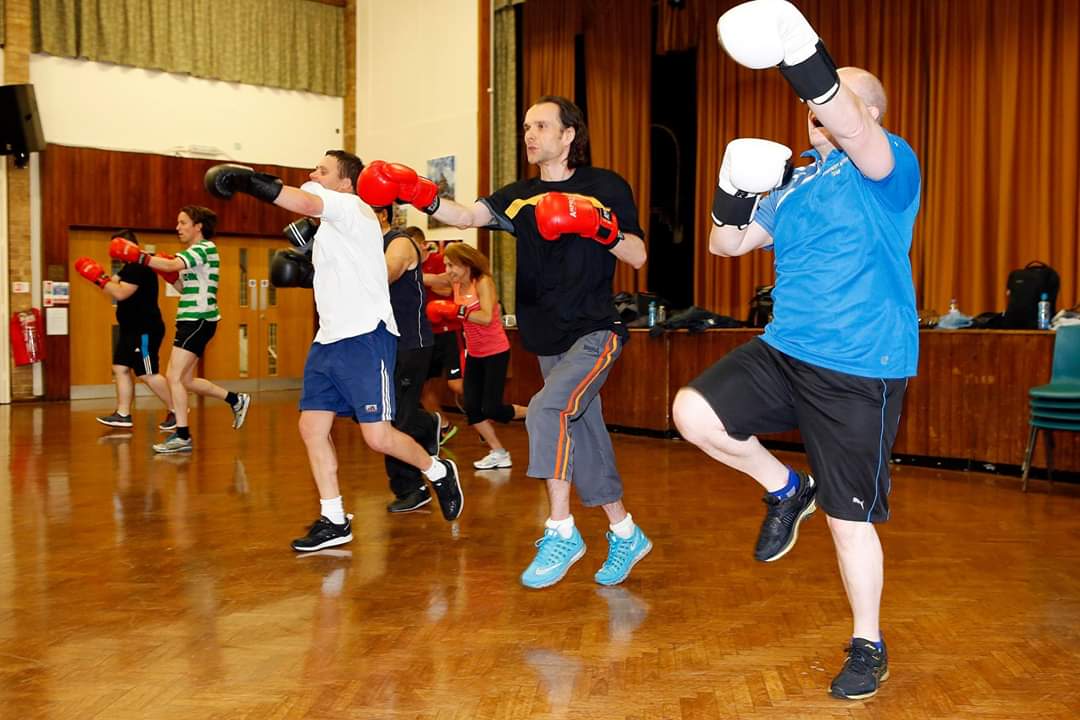 Coach Schwalm putting the class through an intense workout with controlled punches and high knees.