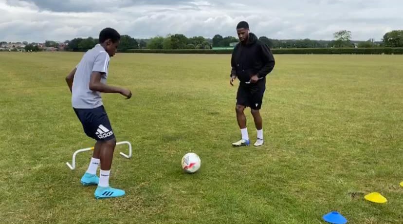 Ola Williams coaching one-on-one with a young boy.