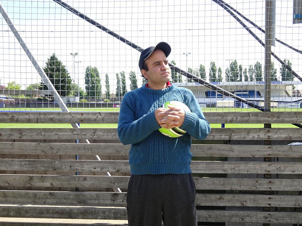A participant at the Wingate & Finchley Disabled Fans Forum standing proud with a football in his arms