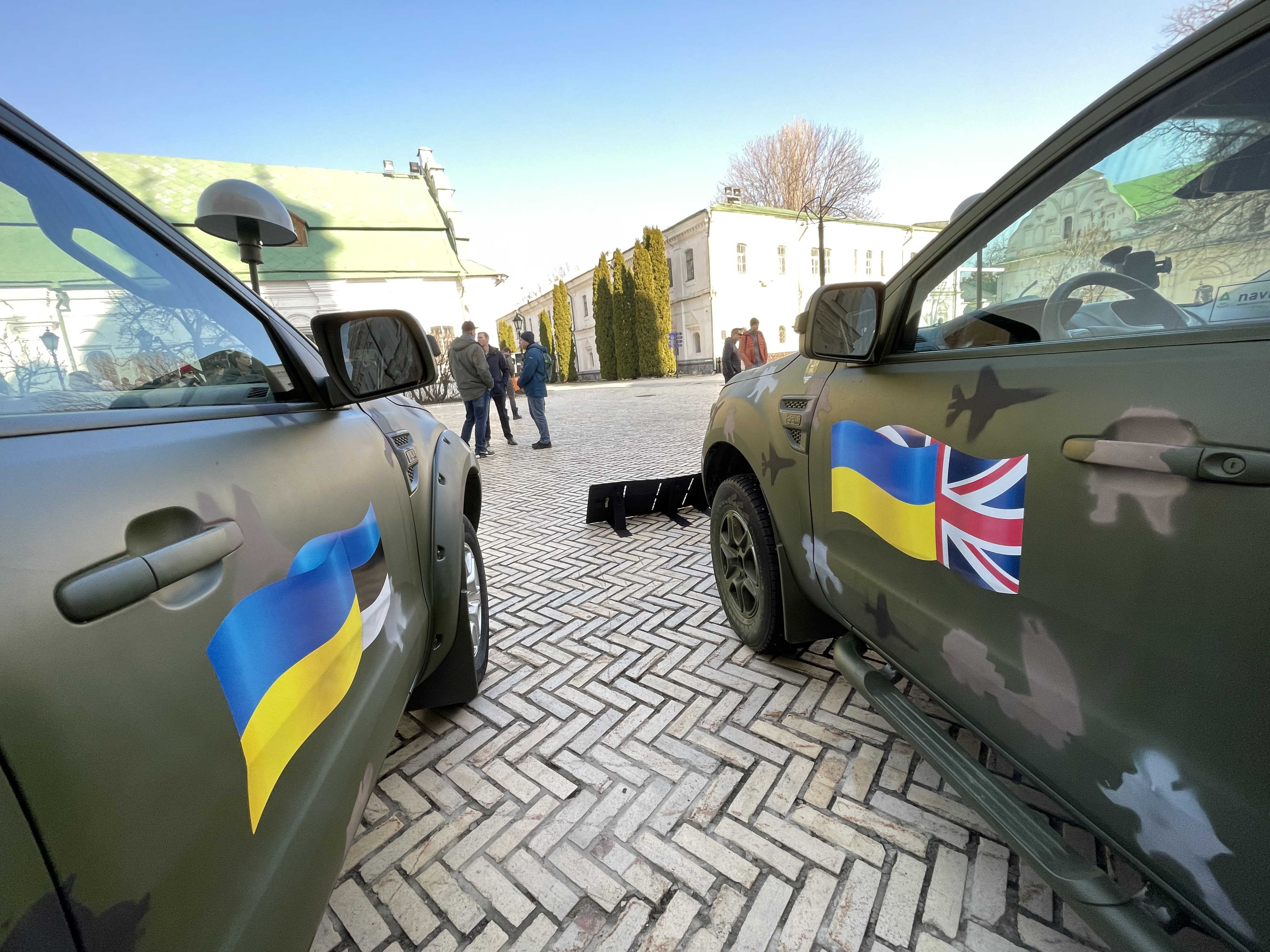 The doors of two vehicles, side by side with a British and Estonian flag painted on the doors.