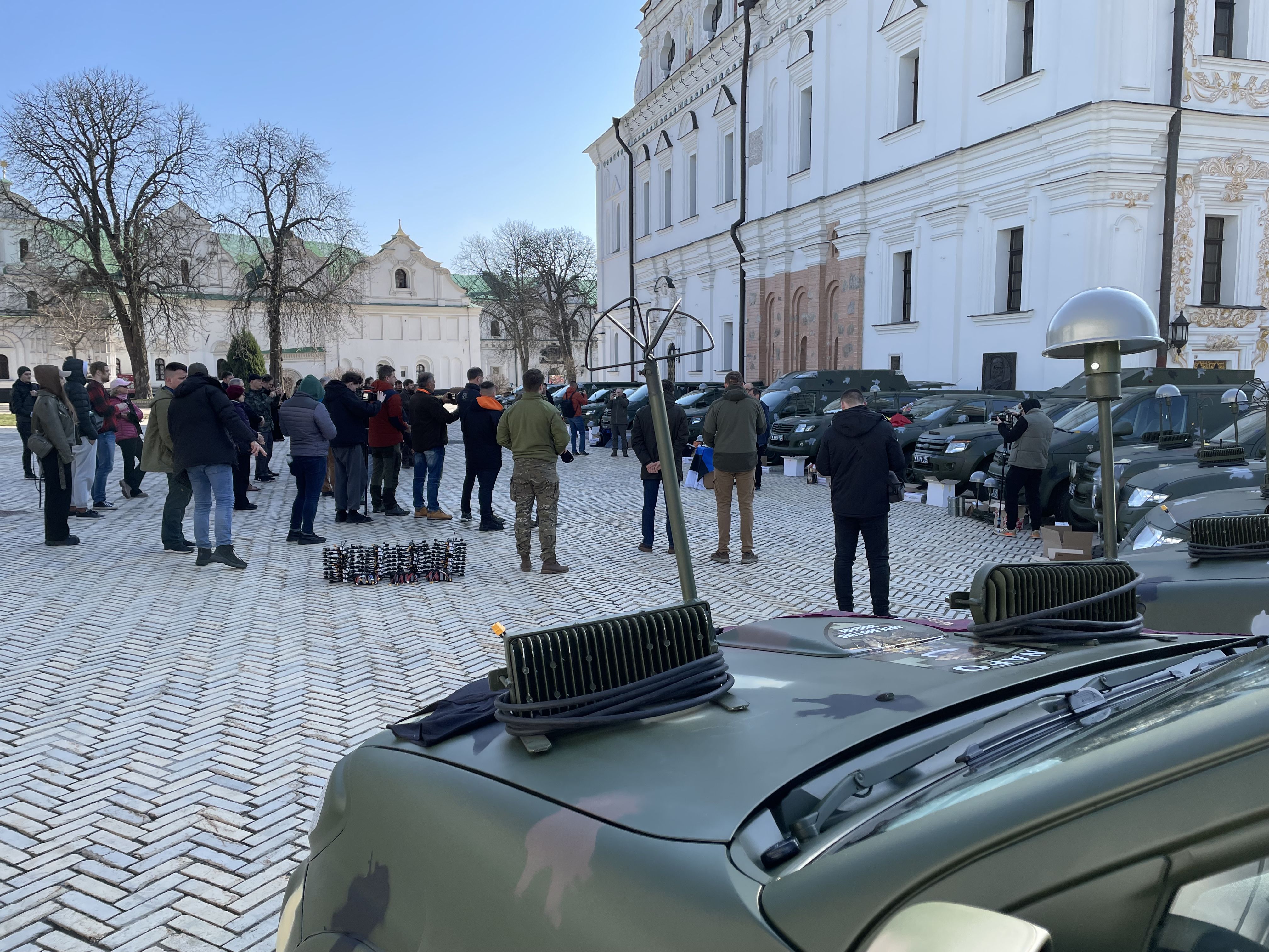People gathering in front of the vehicles for the handover ceremony.