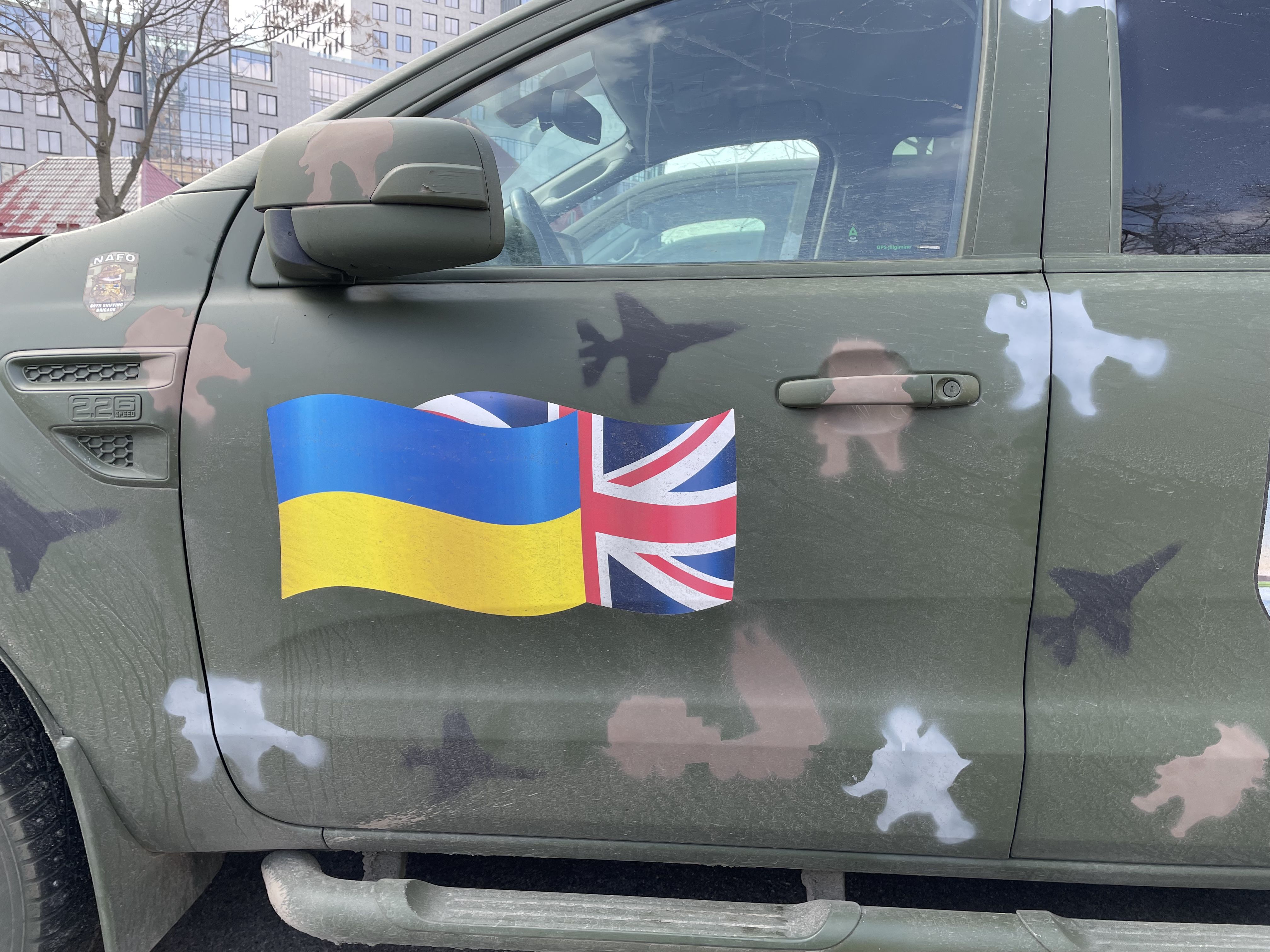 A car with the Ukrainian and British flags painted on the side door.