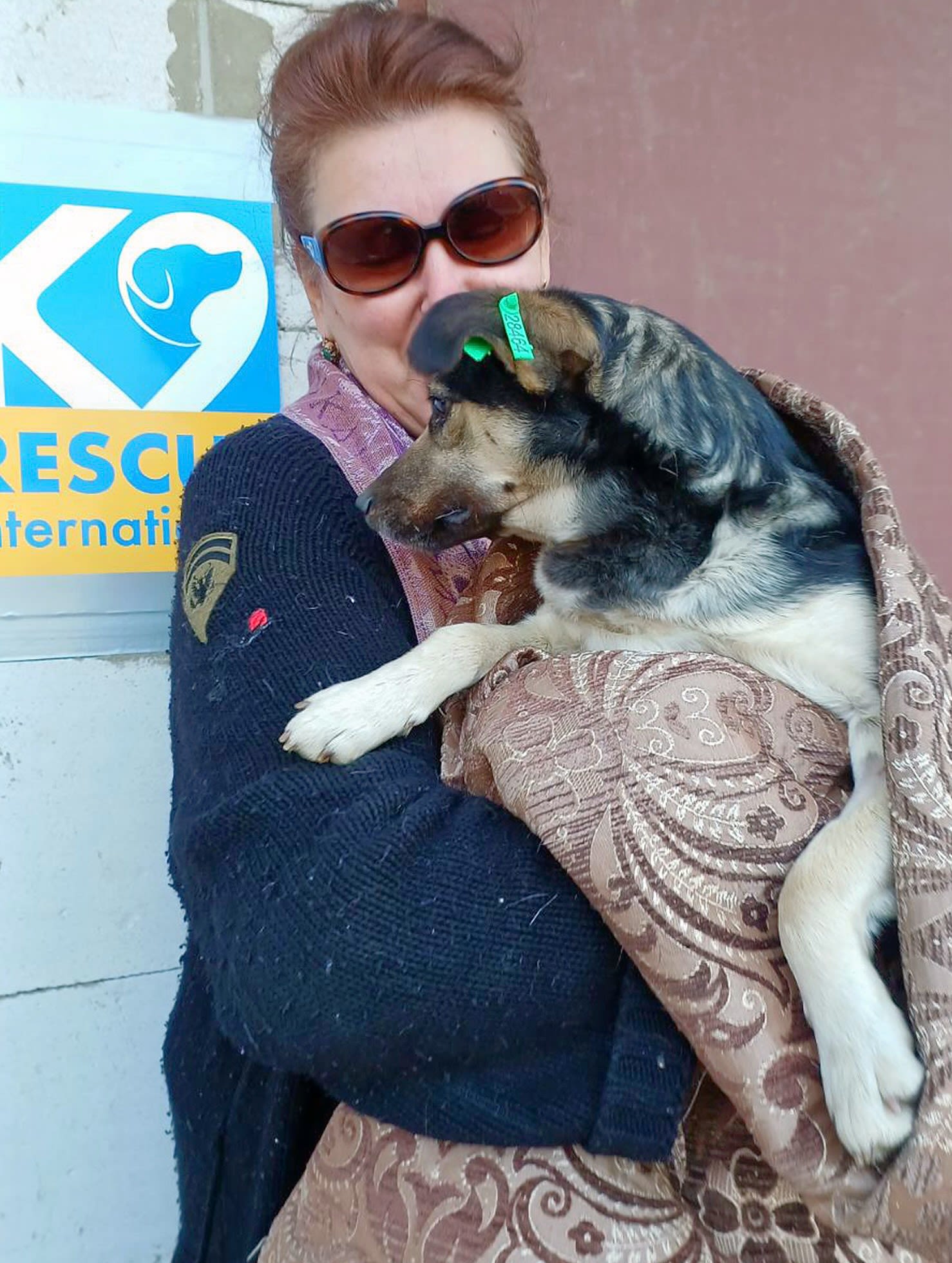 A thrilled owner cuddles her dog after it was spayed at one of K9's spay days for low income families. Image credit: K9 Rescue International